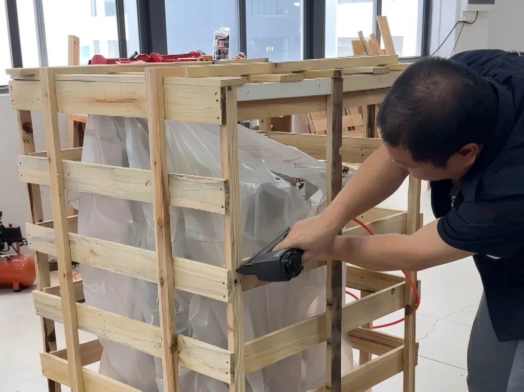 Technician checking protective packing on food processing equipment before shipment
