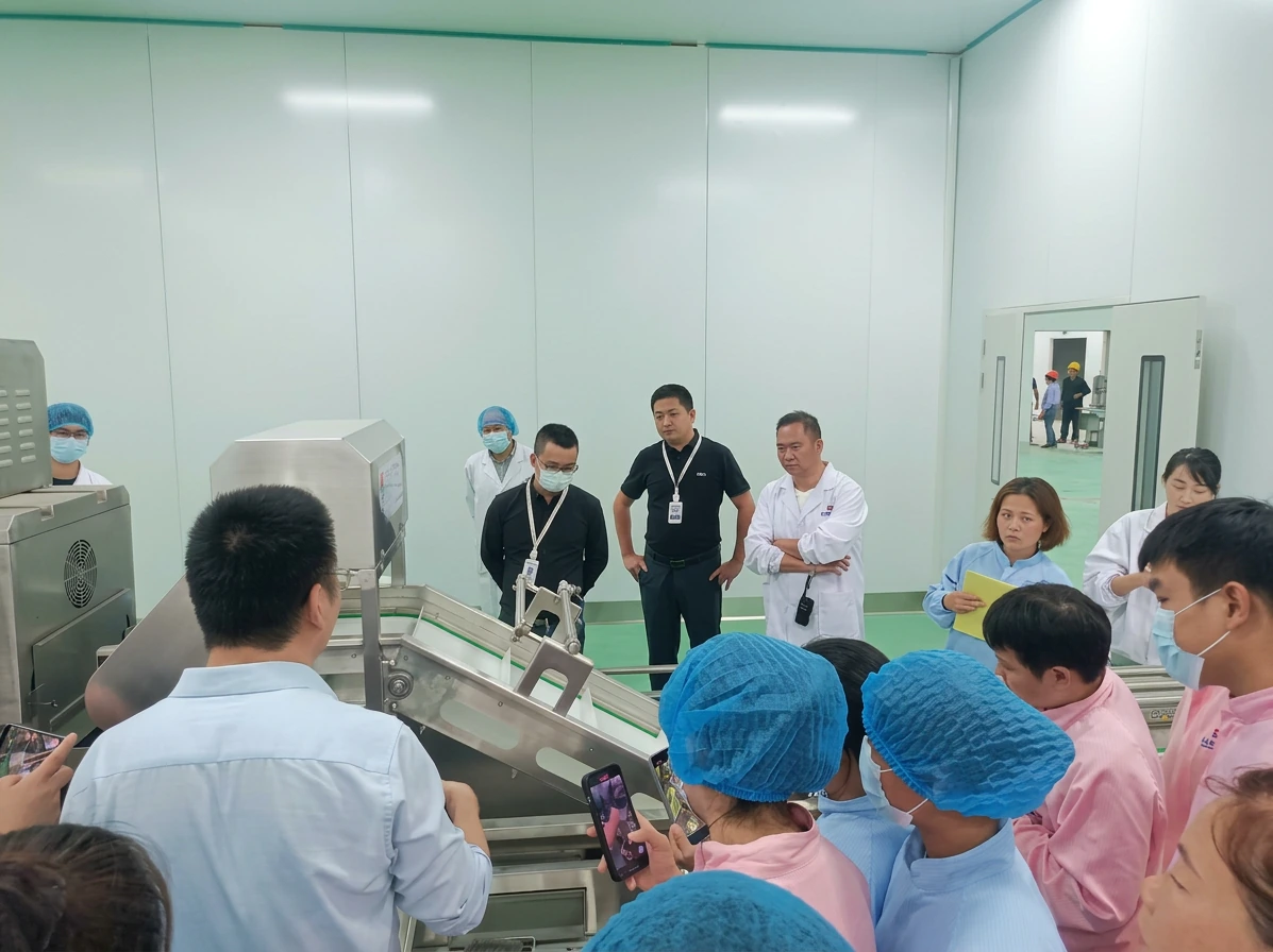 Food production team reviewing a vegetable processing conveyor during equipment training