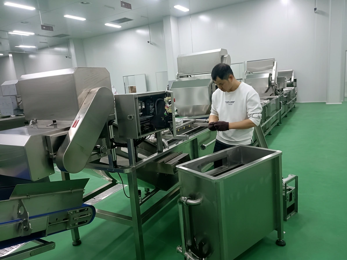 Technician checking control components on a stainless-steel processing line before acceptance testing