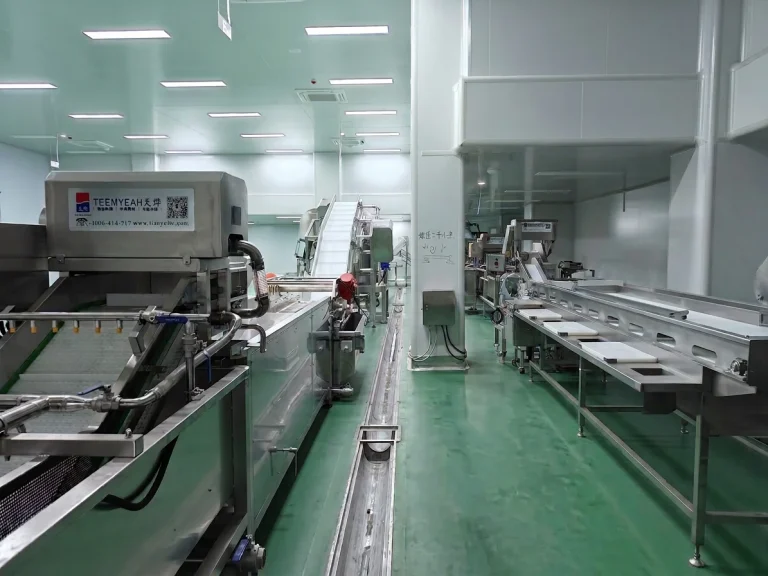 Stainless steel food processing equipment arranged in a clean central kitchen production room
