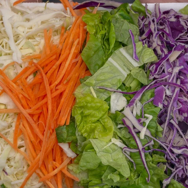 Fresh-cut lettuce, cabbage and carrot showing mixed vegetables after washing and preparation