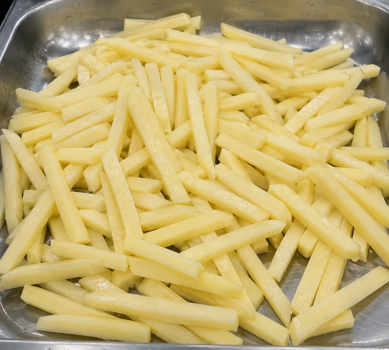Uniform potato batons in a clean tray representing protected finished-product movement